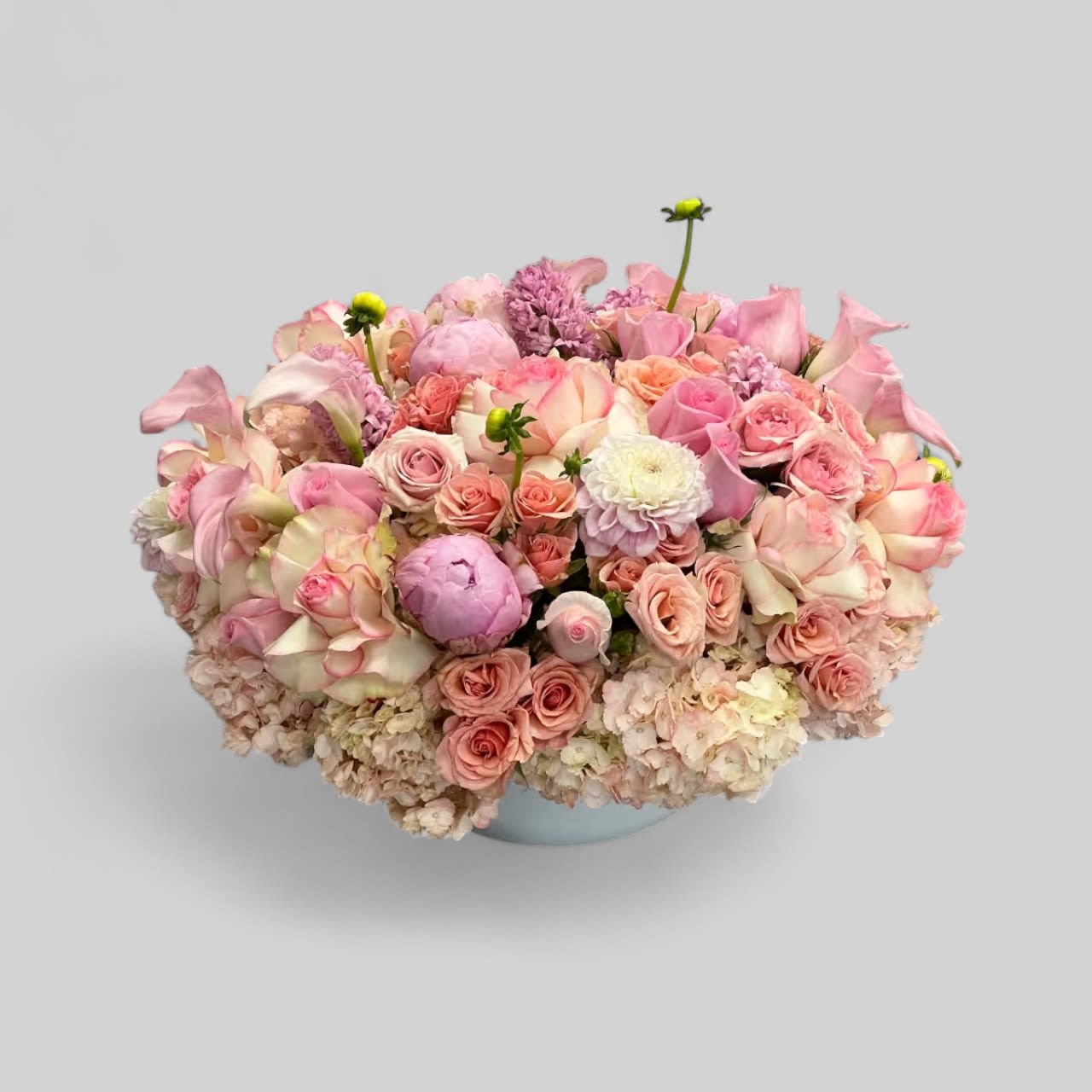 Pastel Fever - A lush, cushion-like dome of pastel blooms-Pastel Fever is a low, rounded flower arrangement perfect for an anniversary bouquet, birthday gift, or a just because surprise. This feminine, elegant centerpiece puts dahlias, hydrangeas, peonies, roses and mini calla lilies front and center in soft pink and white tones, so the person you're thinking of will feel genuinely celebrated the moment they see it. Its romantic palette also makes a lovely choice for graduations, housewarmings, new baby bouquets, get well wishes, or spring 