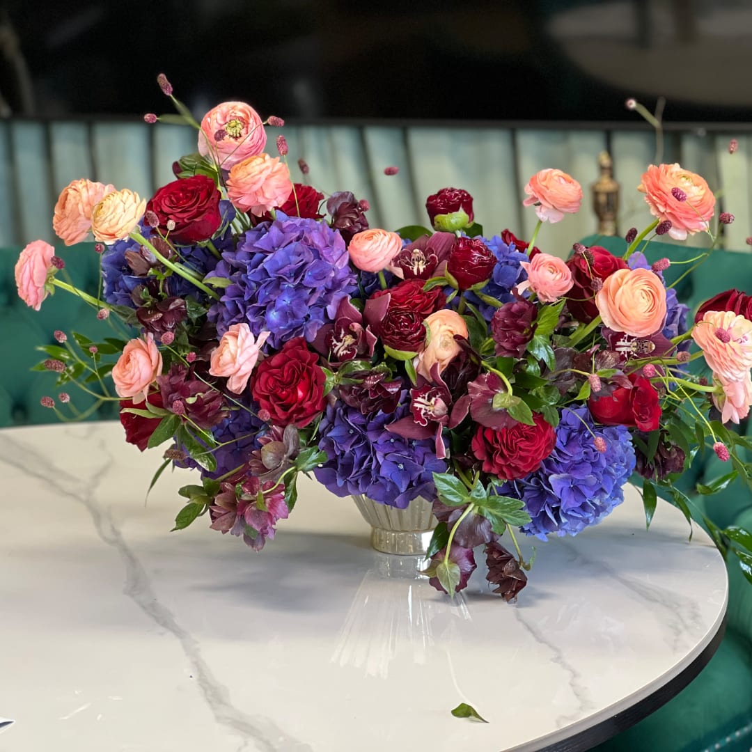 Colorful bouquet of roses and hydrangeas in a clear vase
