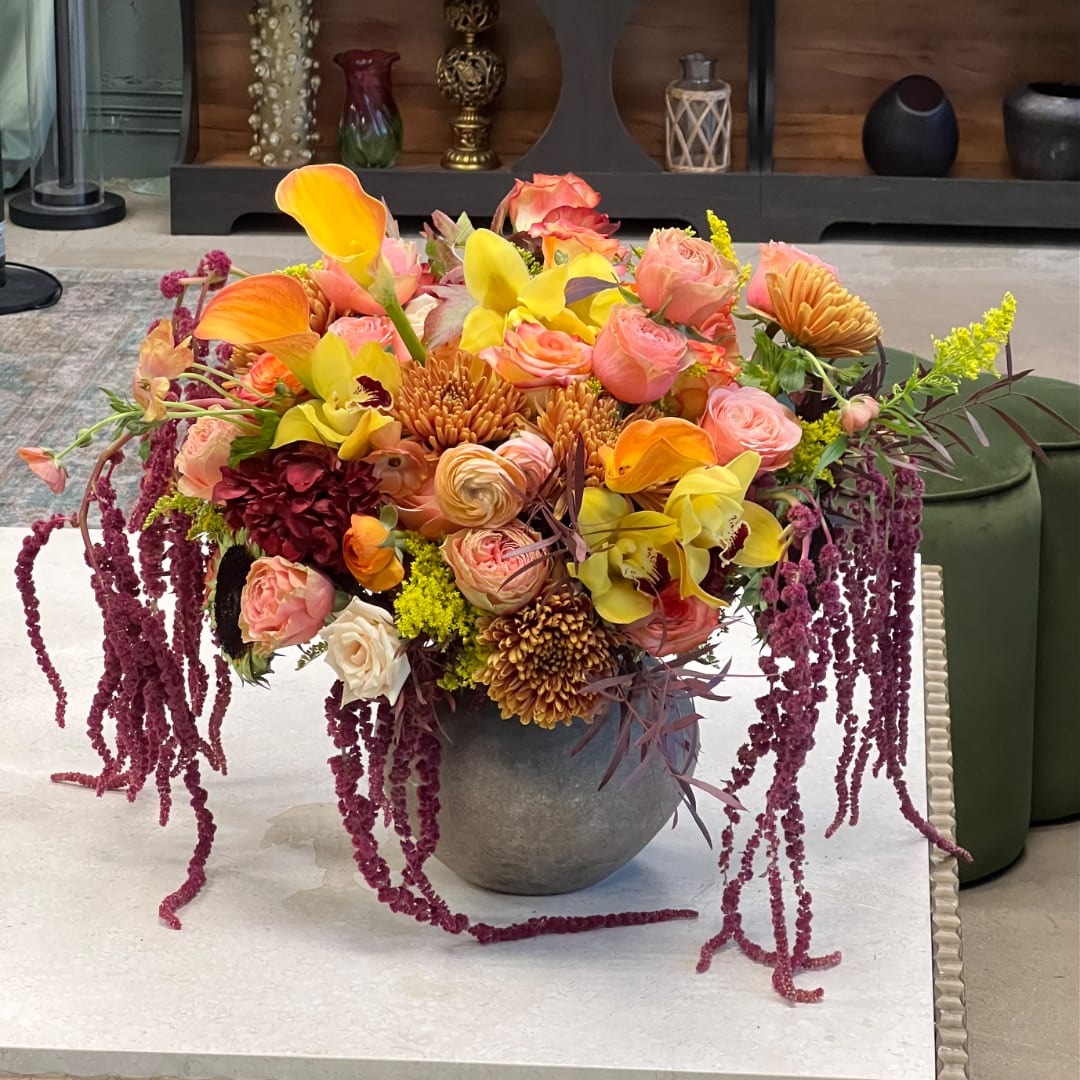 Colorful mixed bouquet in a gray vase with cascading purple blooms