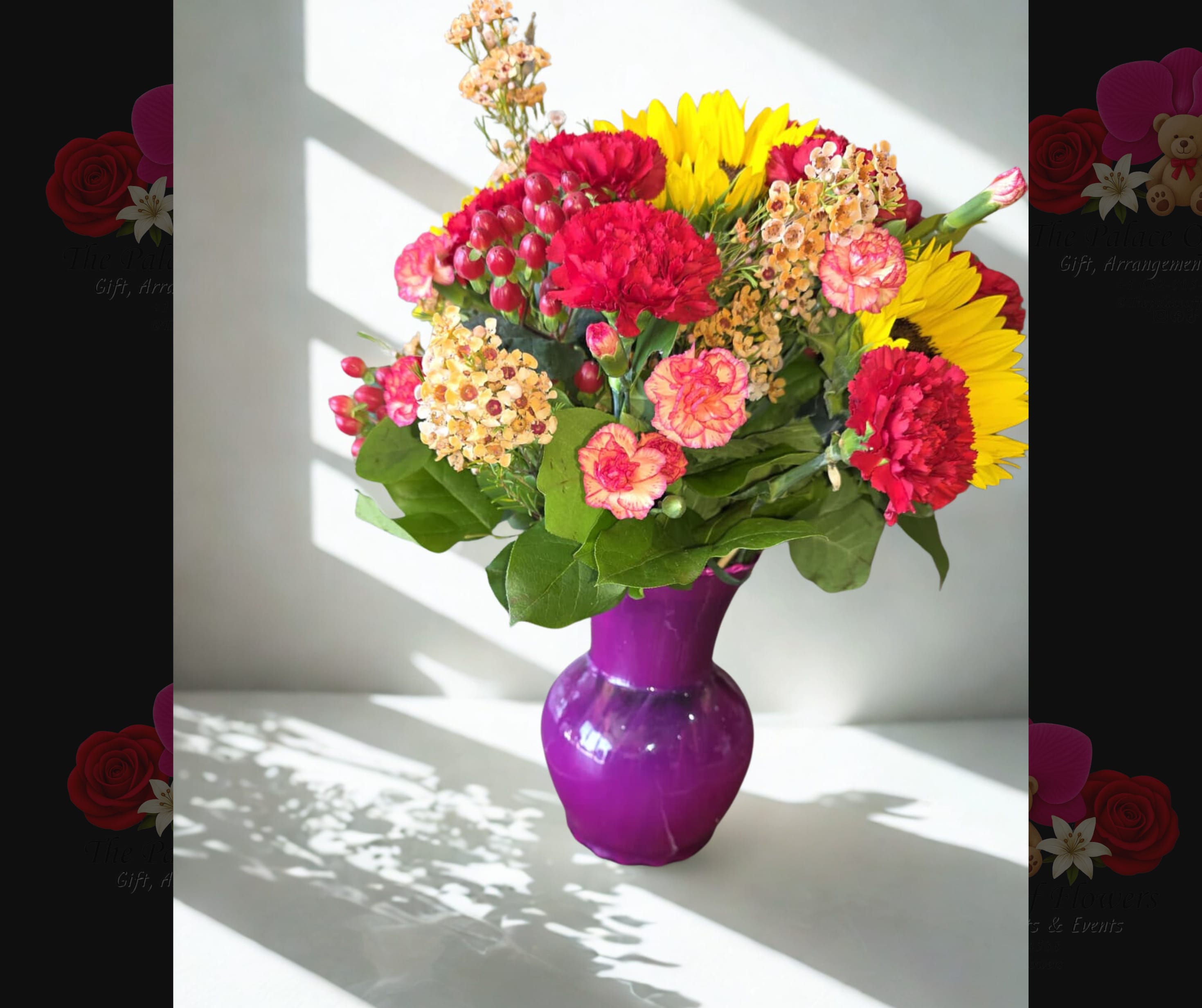 Mixed bouquet of red, pink, and yellow flowers in a purple vase