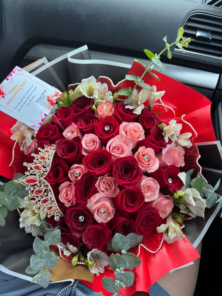 Bouquet of red and pink roses with white alstroemeria and decorative accents