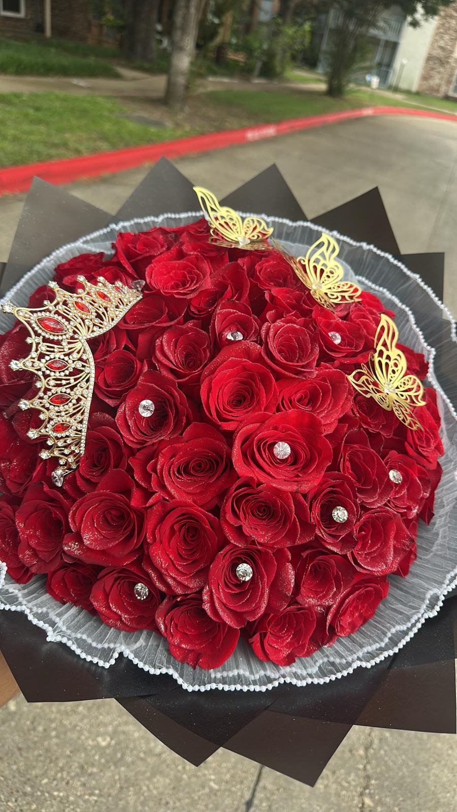 Bouquet of red roses with gold butterfly accents and a jeweled crown decoration