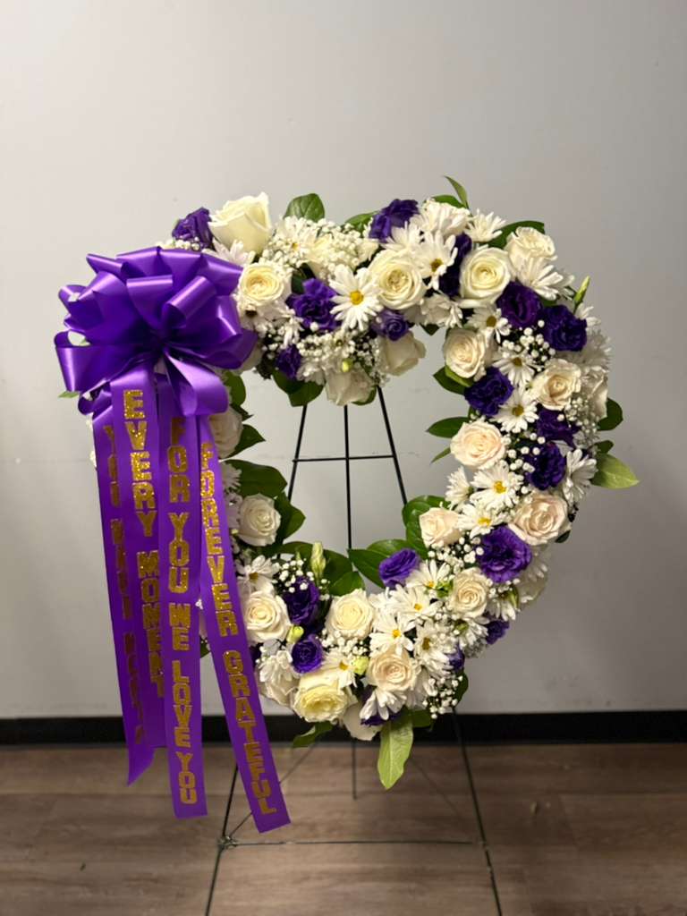 Heart-shaped floral wreath with purple ribbon and white and purple flowers