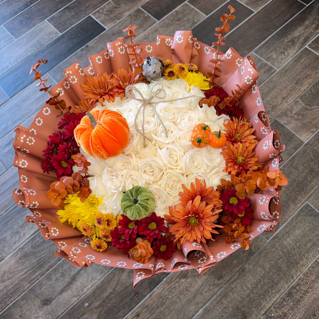 Bouquet of white roses with orange and red flowers and small pumpkins