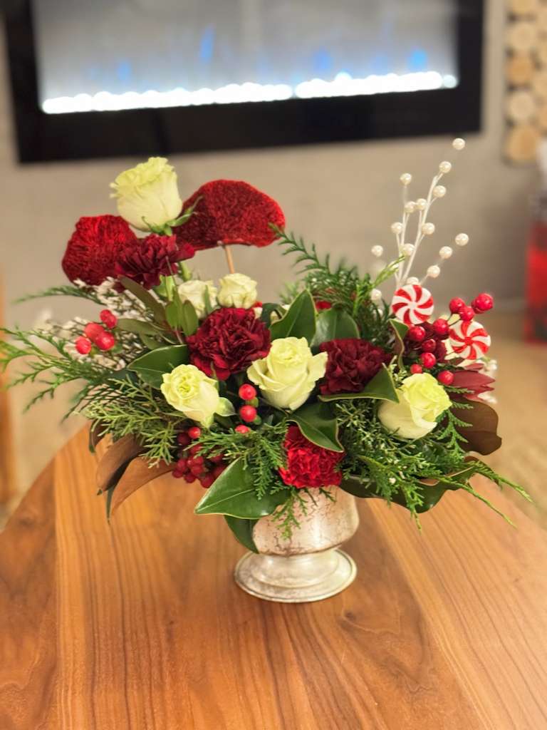 Holiday Elegance Floral Arrangement – Limited Availability - Our Holiday Elegance Floral Arrangement is a refined seasonal design created with classic Christmas tones and natural greenery.  Featuring seasonal florals, rich textures, and festive details, this arrangement brings warmth and timeless elegance to any space.  Perfect for holiday tables, living spaces, offices, or as a thoughtful seasonal gift.  Each piece is handcrafted with care and offered in limited quantities to ensure quality and exclusivity.