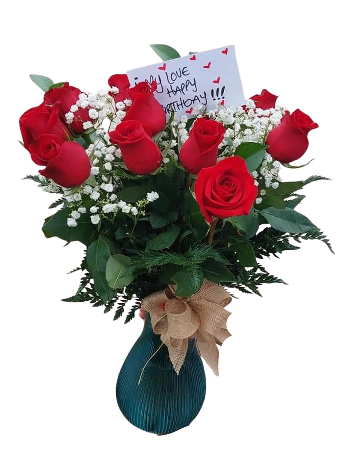 Bouquet of red roses in a vase with a birthday card