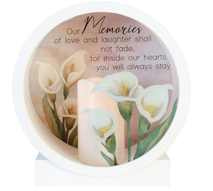 Memorial candle with white calla lilies and a remembrance message