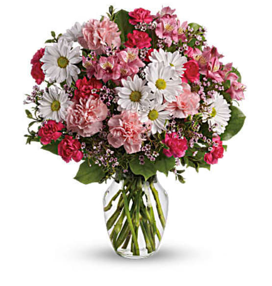 Mixed pink and white flowers arranged in a clear glass vase