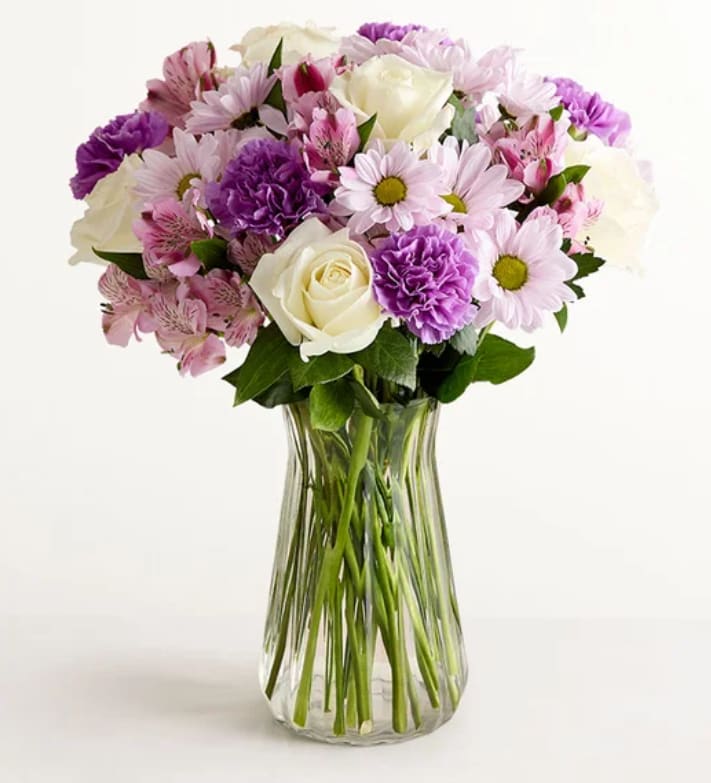 Bouquet of pink and purple flowers in a clear glass vase