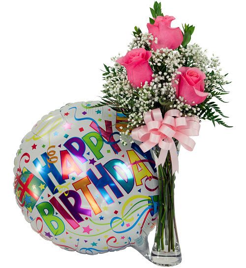 Pink roses in a glass vase beside a birthday balloon