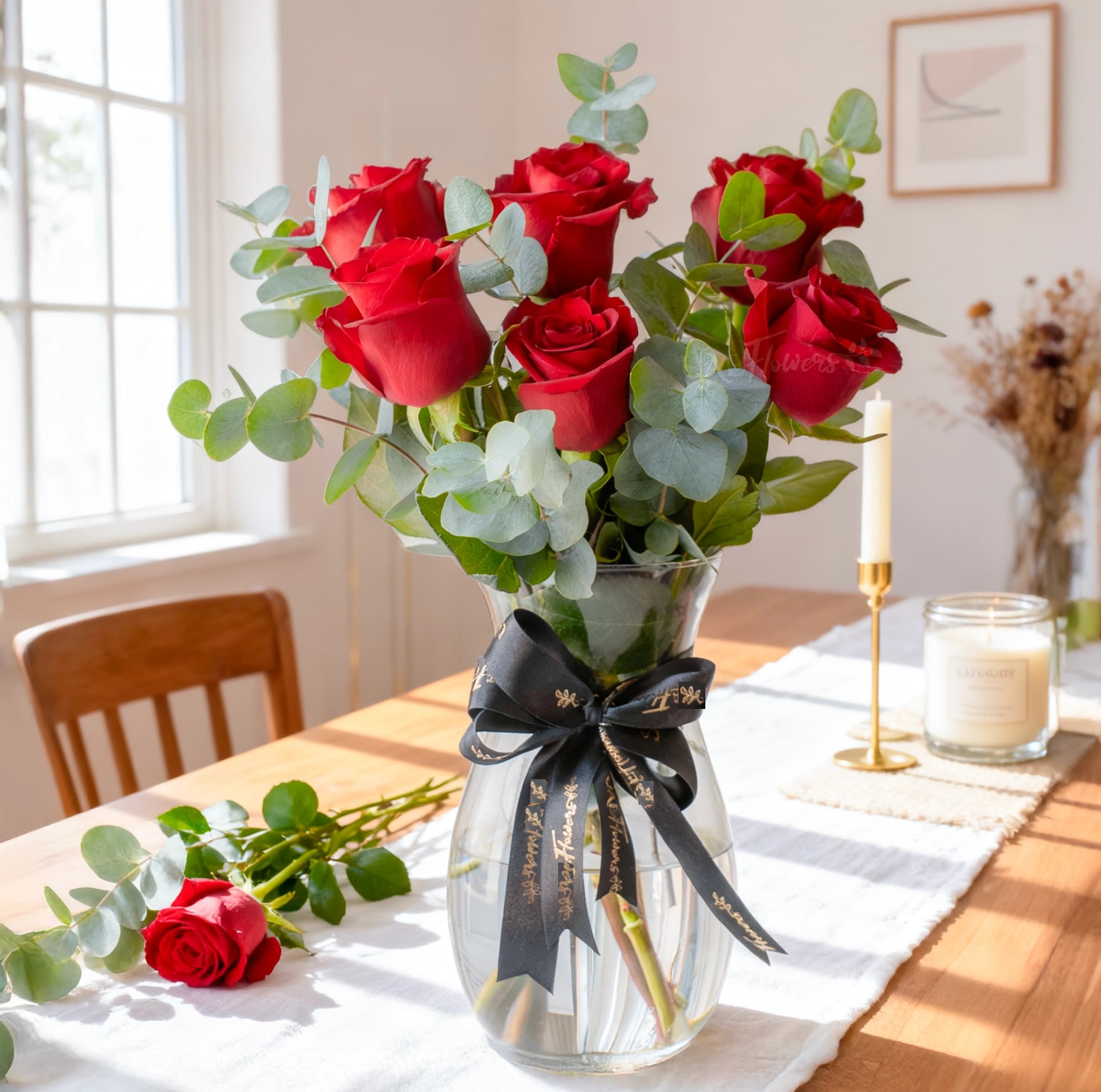 Bouquet of red roses in a clear glass vase with a black ribbon