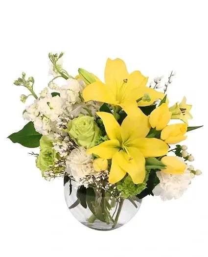 Yellow lilies and white flowers in a clear glass vase