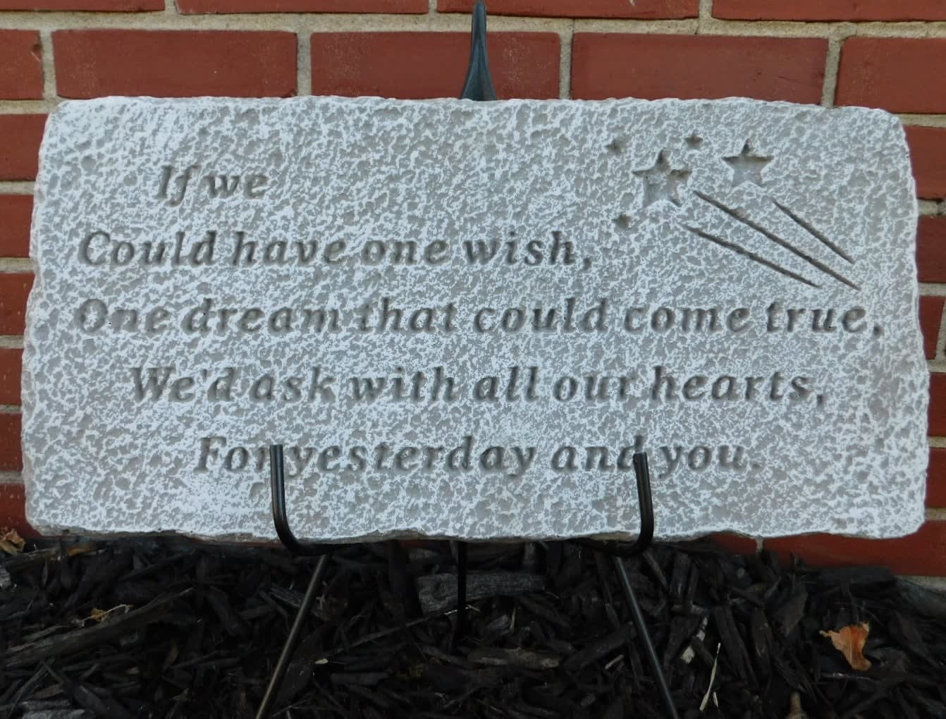 Decorative stone plaque with an engraved wish quote and shooting stars