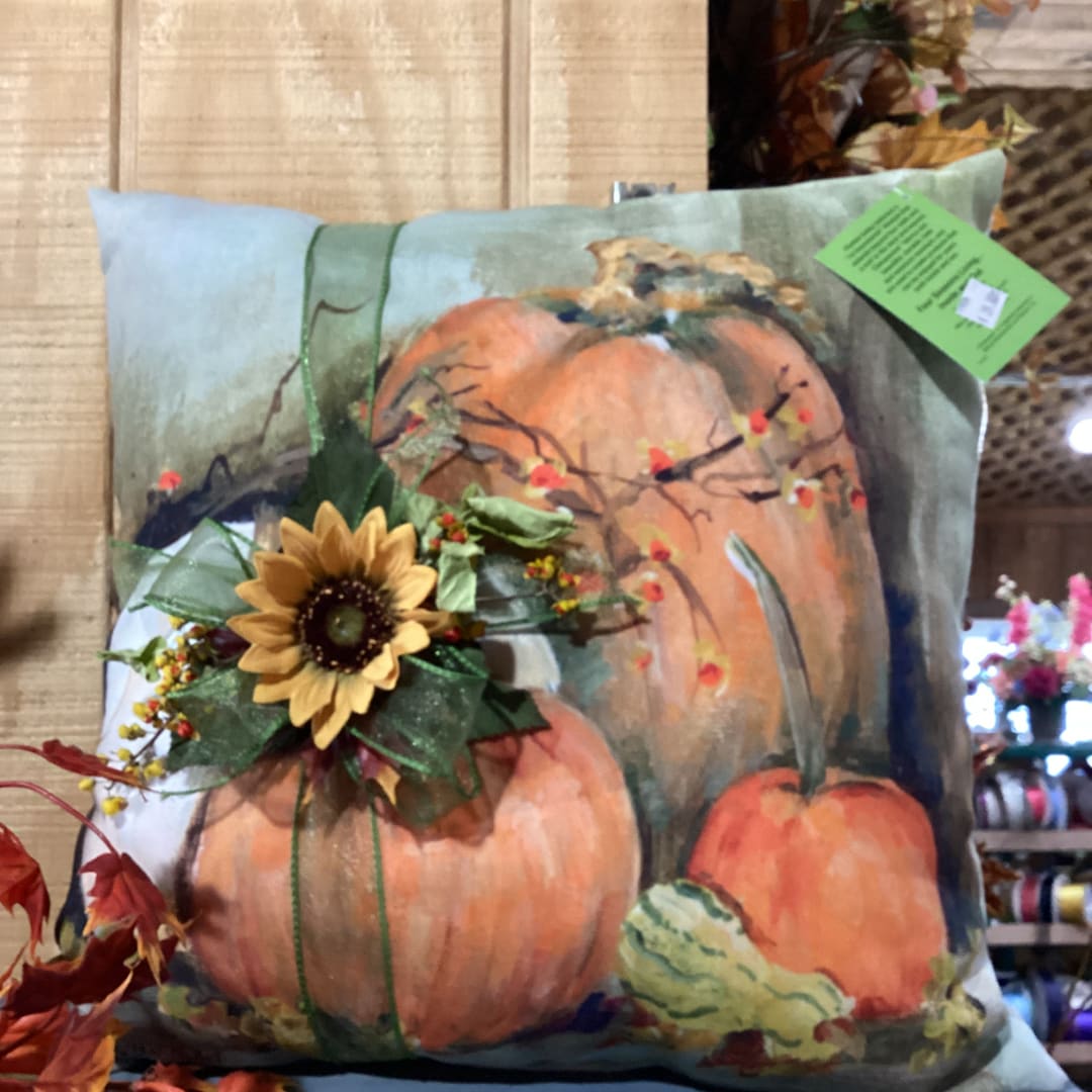 Decorative pillow with pumpkins and a sunflower accent