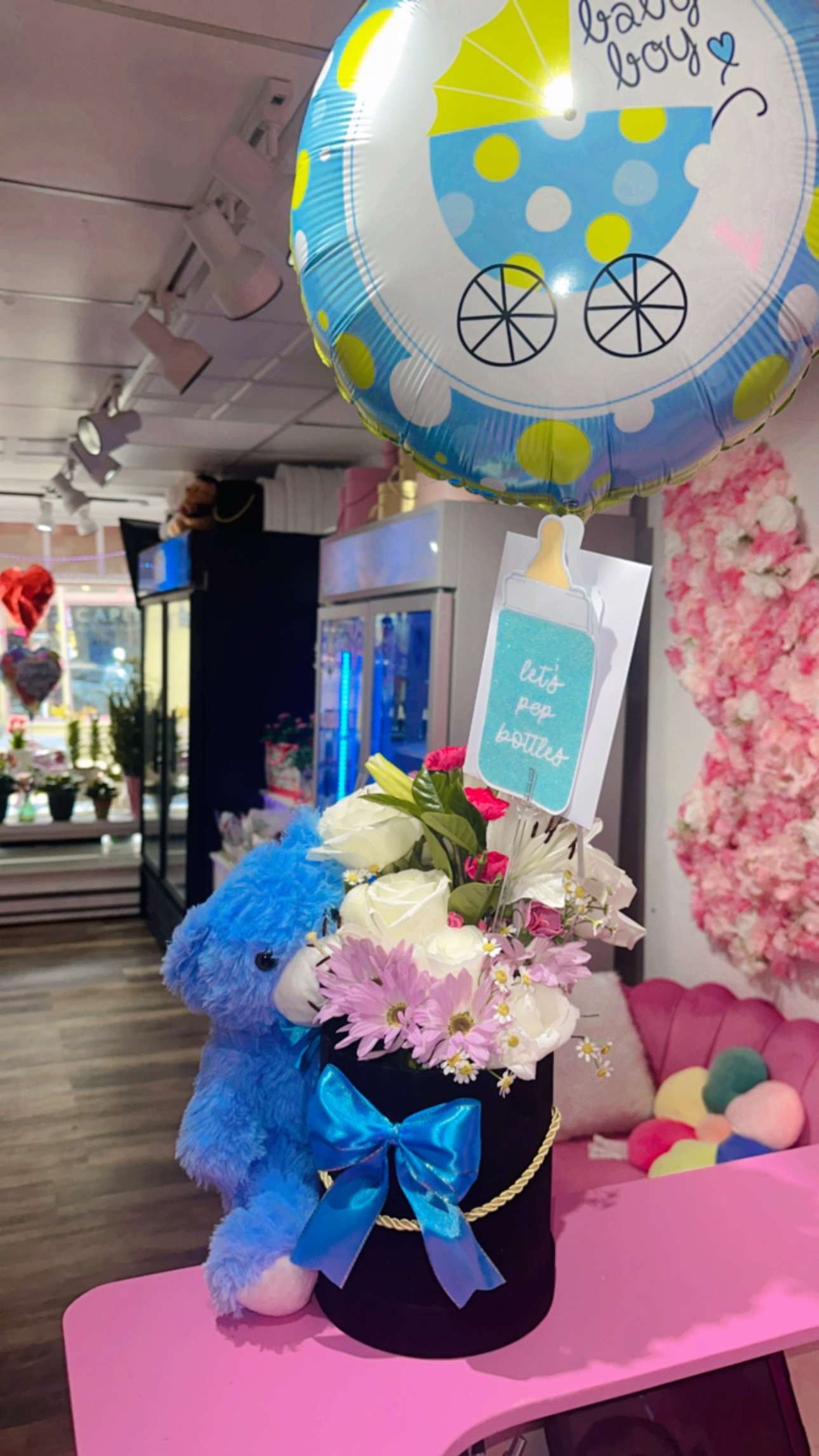 Its a baby boy arrangement  - celebrate with blue teddy bear, white roses, and filling flowers in a black round gift box. Perfect for welcoming a baby boy.