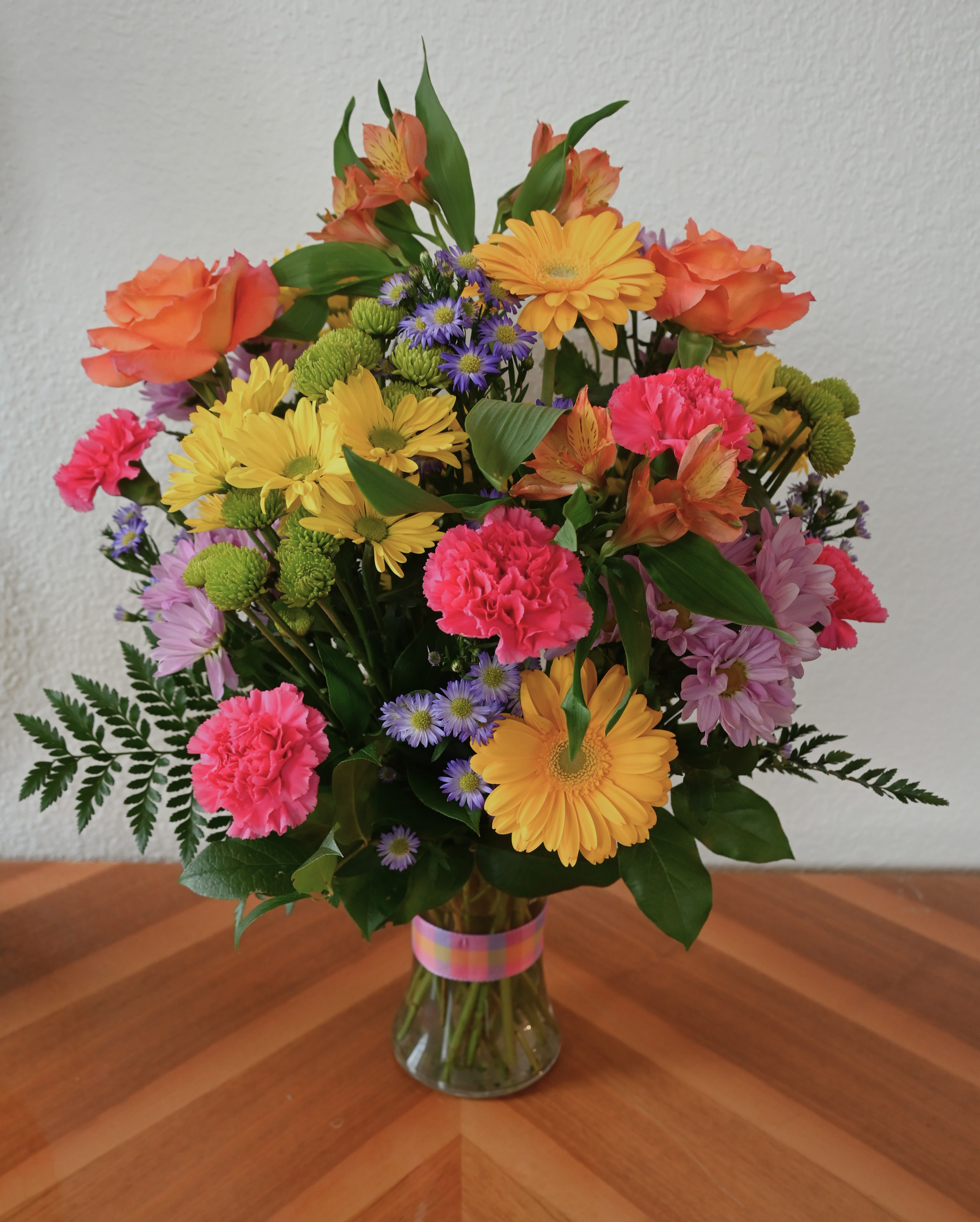 Bright &amp; Joyful - This bright and cheerful bouquet is bursting with colorful daisies, roses, gerbera daisies, and more. It is the perfect arrangement for celebrating life's joyful moments or simply brightening someone's day.