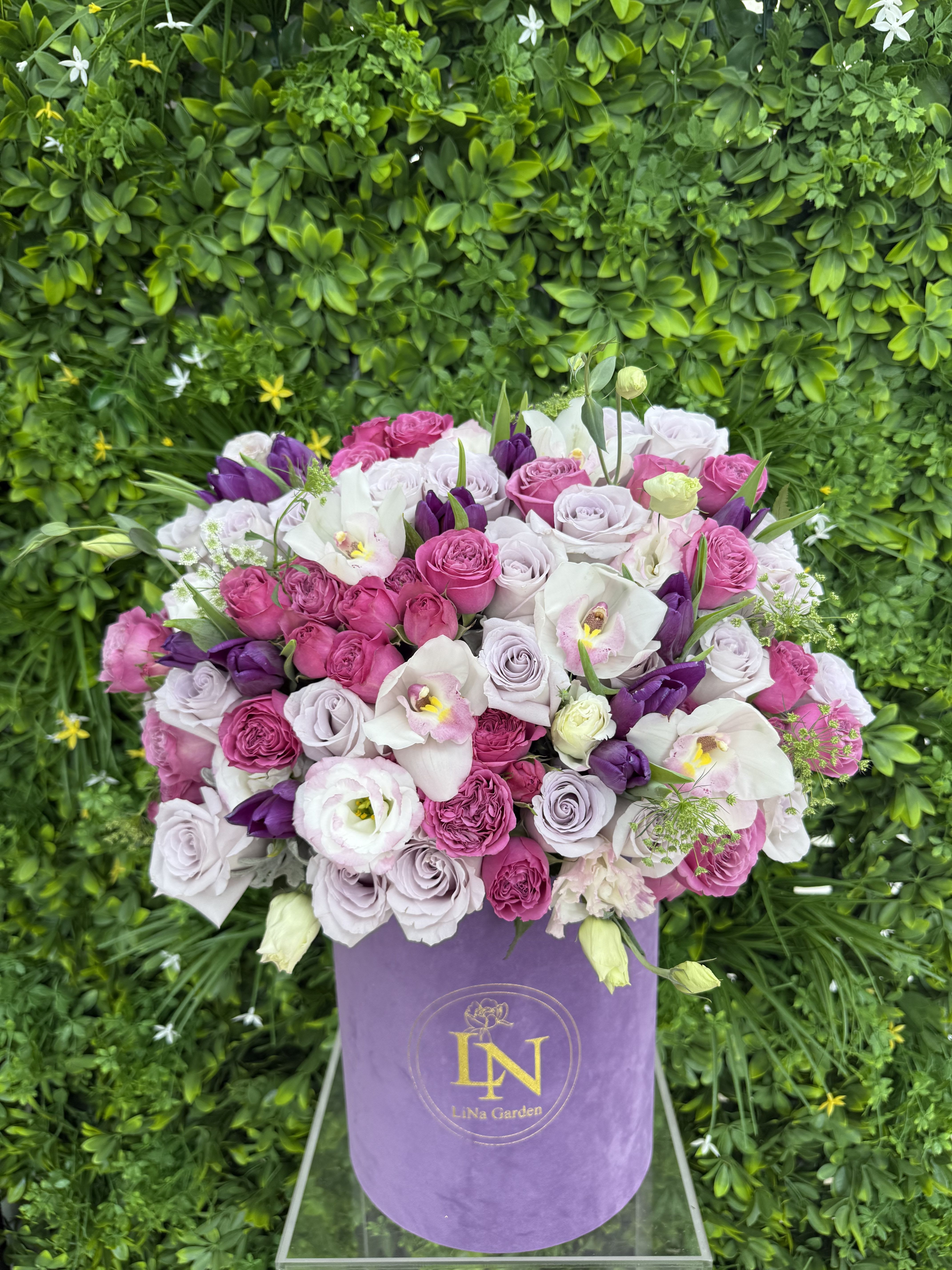 Pink, lavender, and white roses in a purple hat box