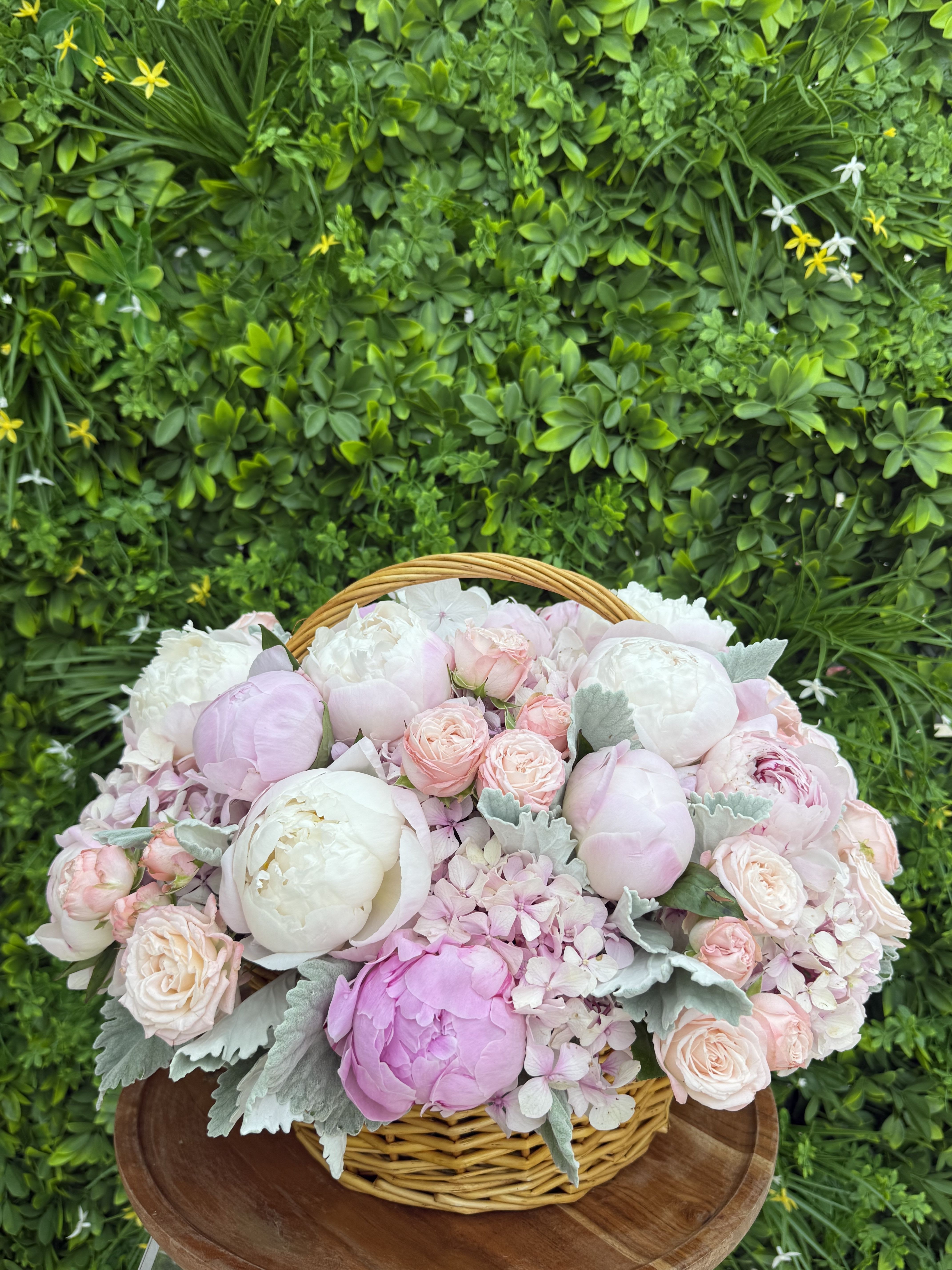 Pastel pink and white flowers arranged in a wicker basket