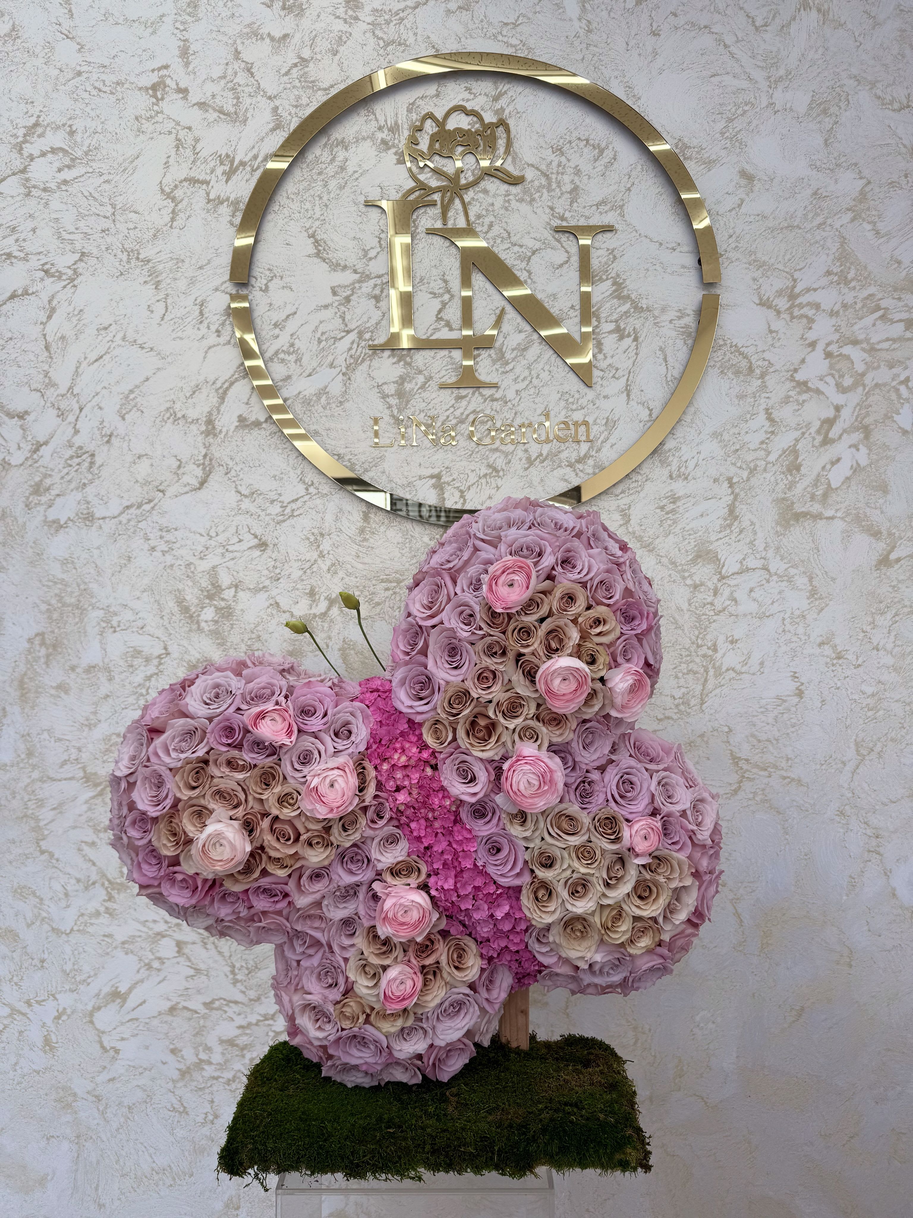 Butterfly-shaped floral arrangement of pink and lavender roses