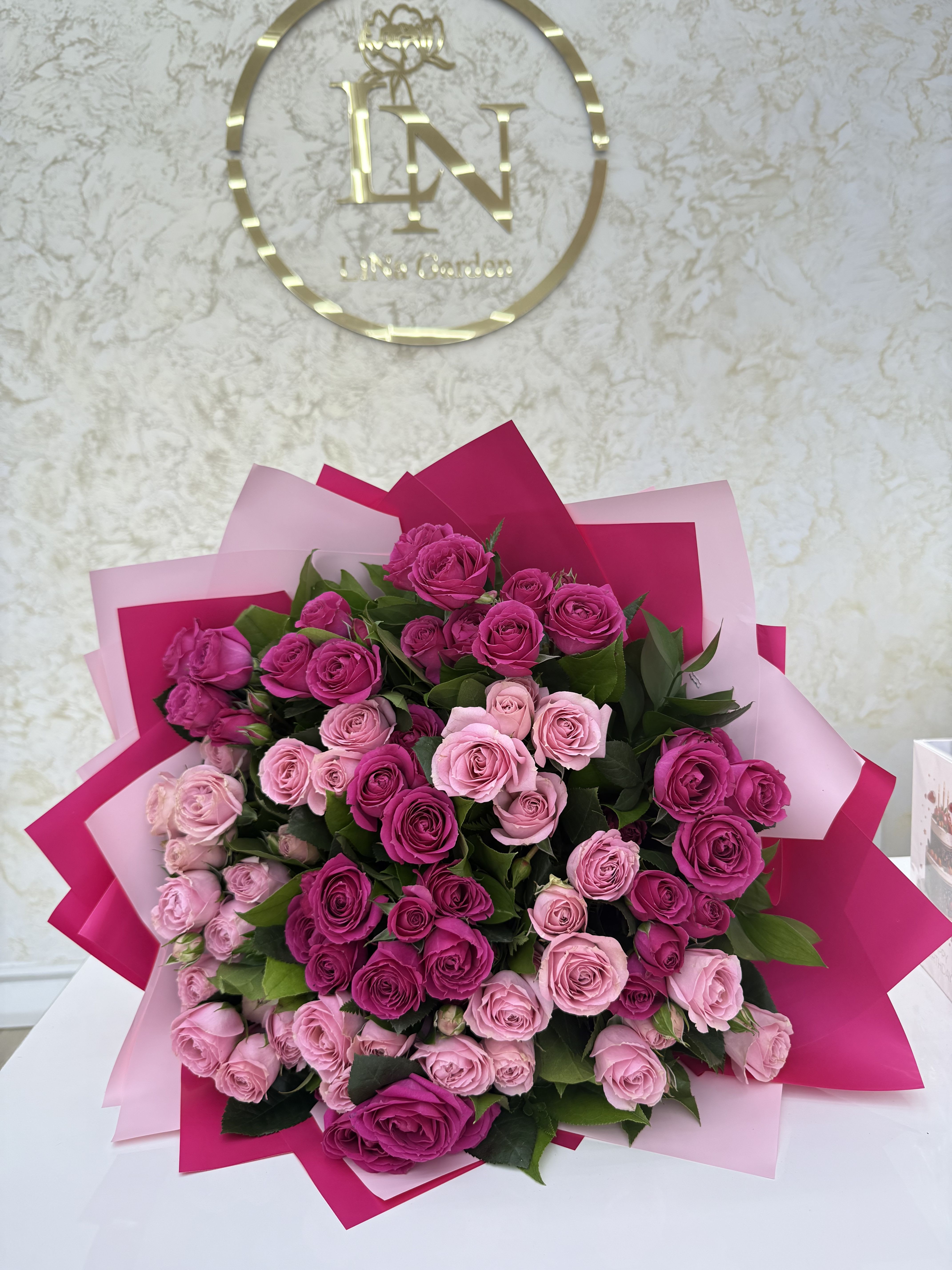 Bouquet of pink and magenta roses wrapped in pink paper