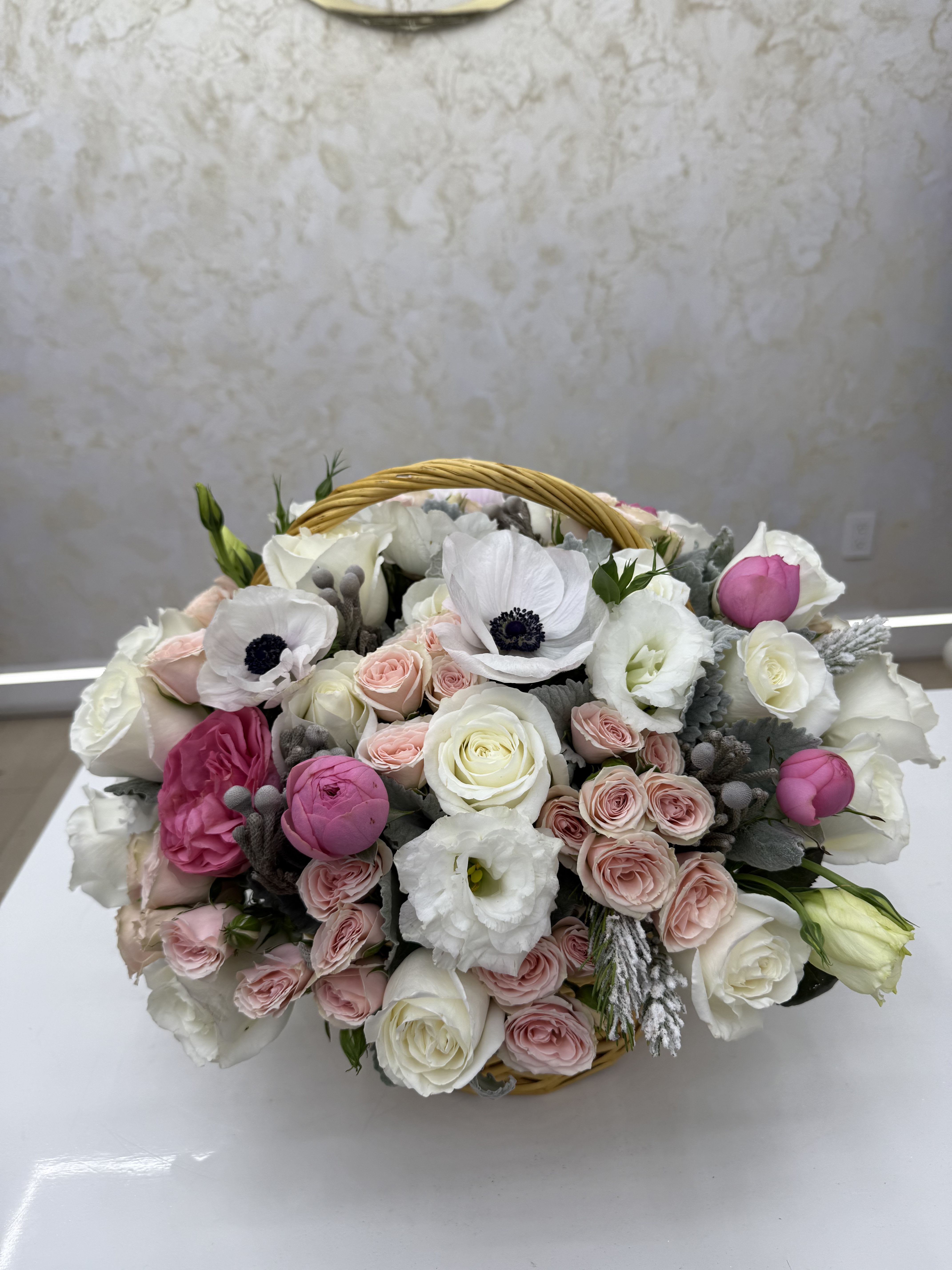 Basket of white and pink roses with white anemones