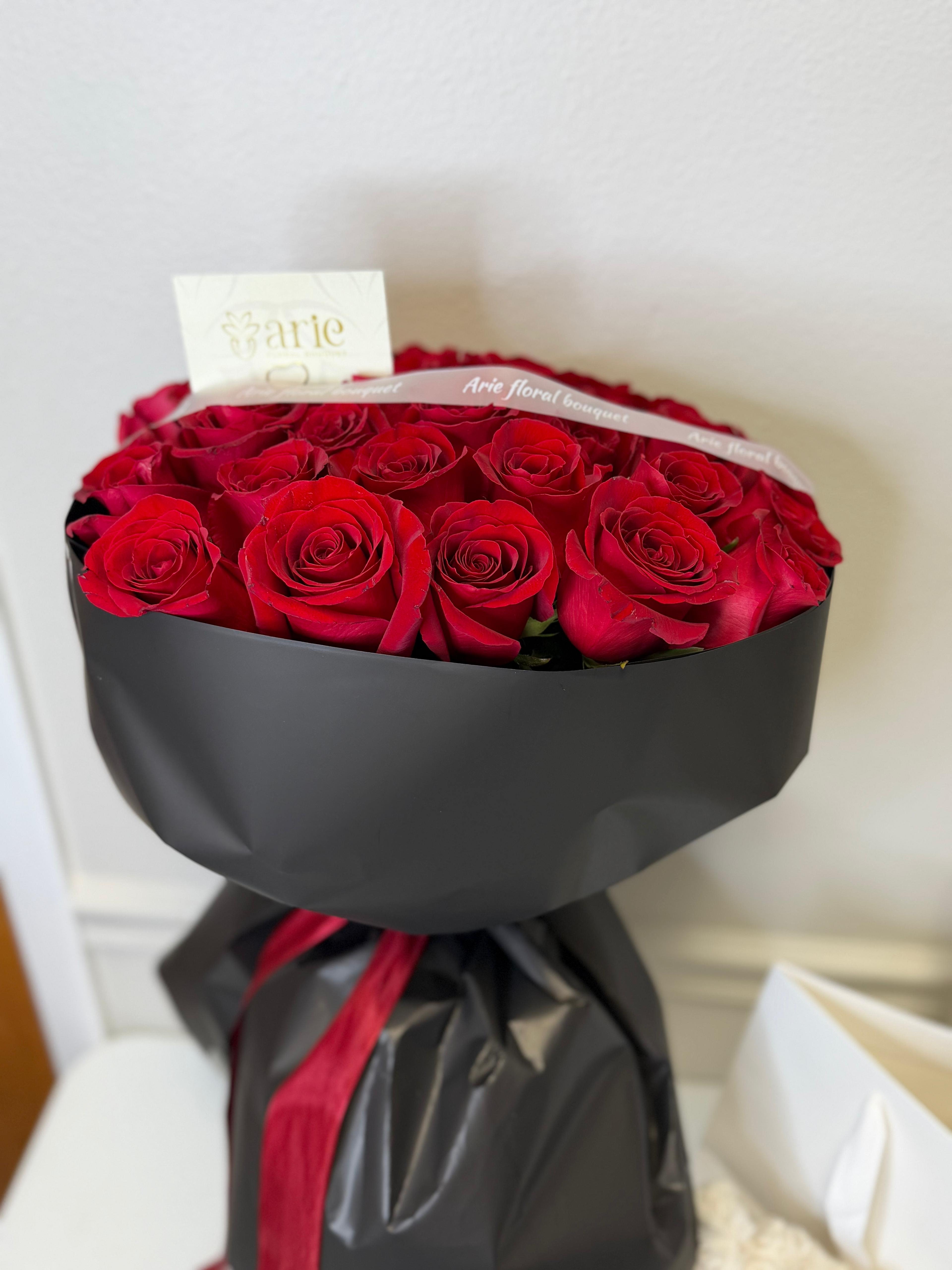 Bouquet of red roses wrapped in black paper