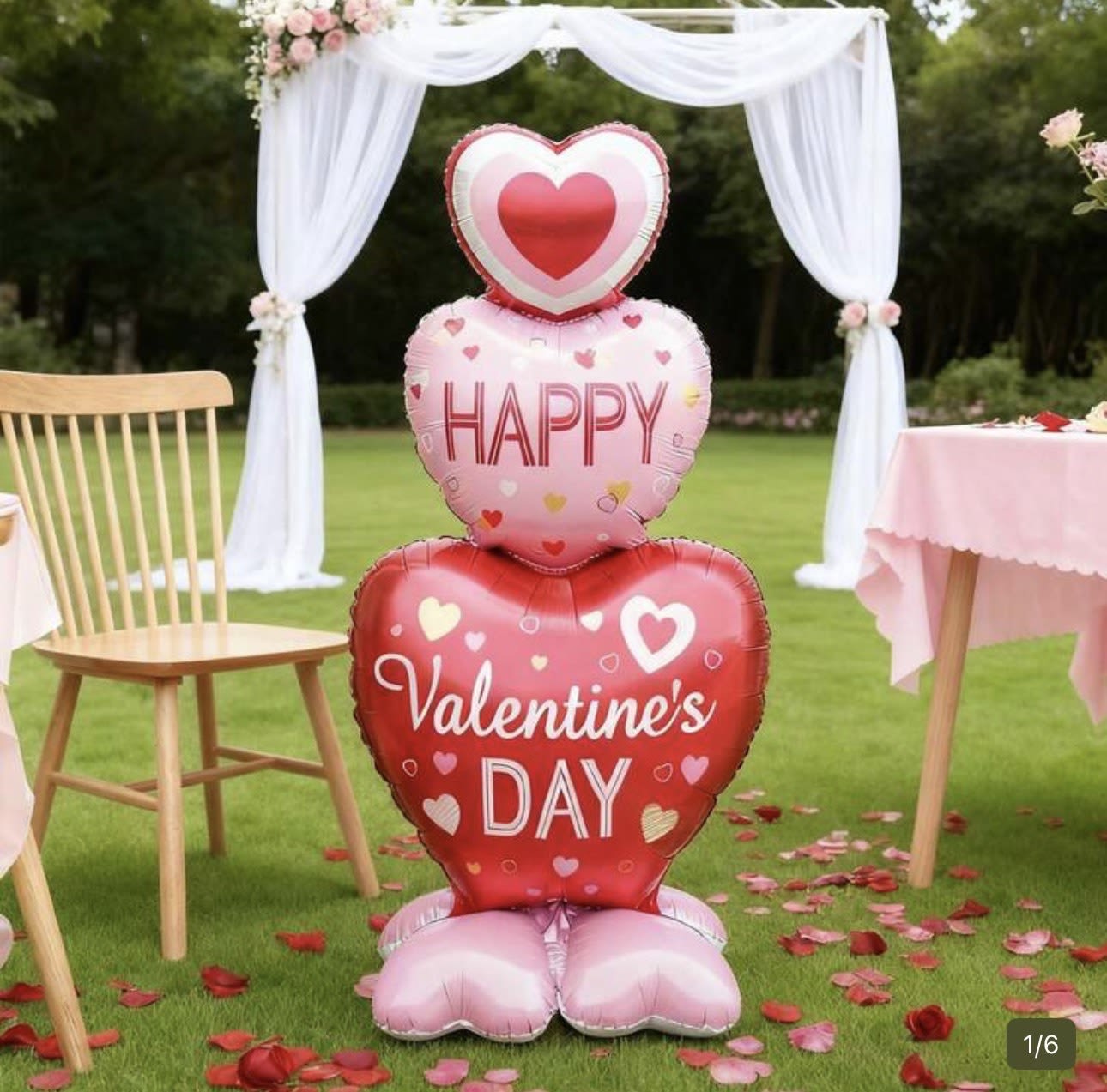Heart-shaped Valentine's Day balloons stacked outdoors with white drapery