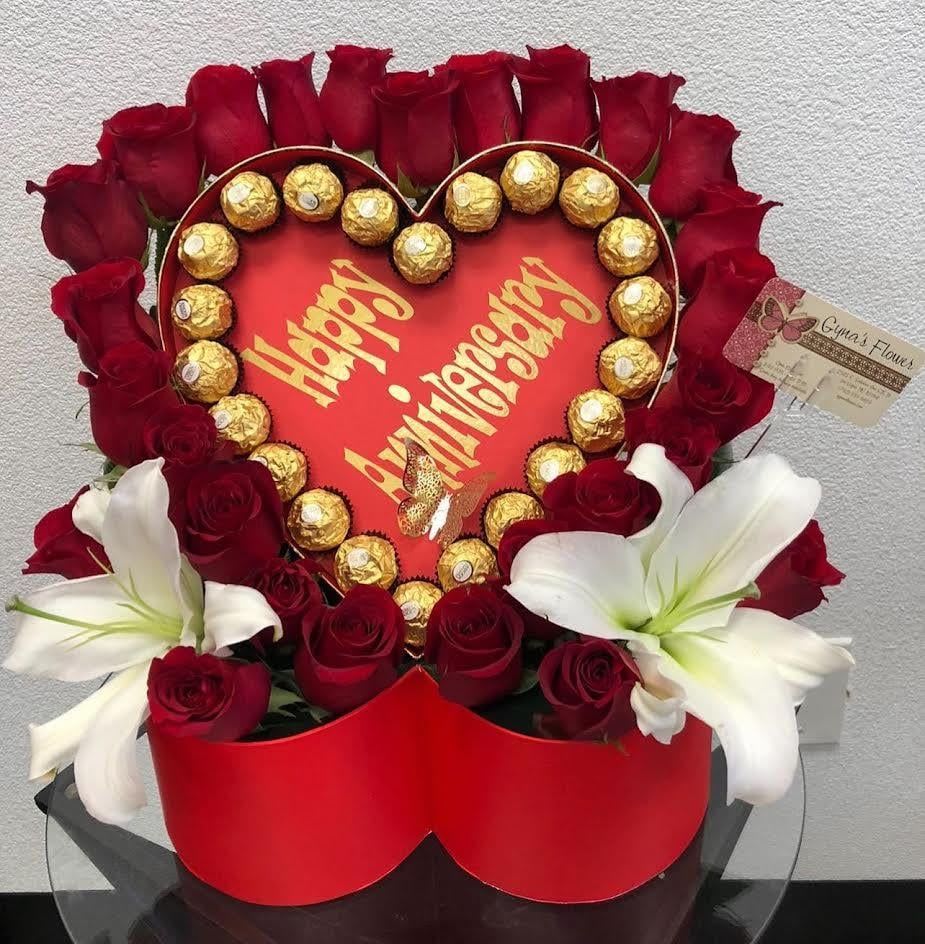 Heart-shaped rose arrangement with chocolates and white lilies
