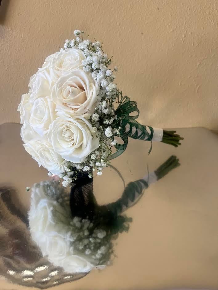 White rose bouquet with baby's breath and green ribbon wrap