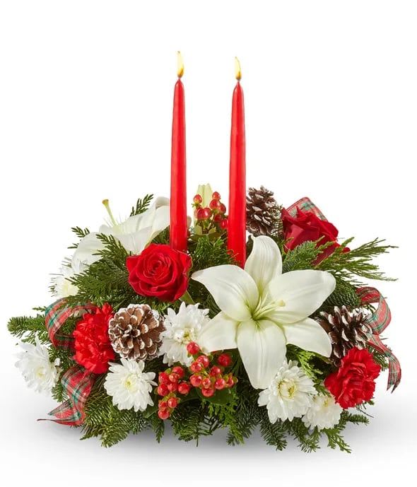 Holiday centerpiece with red candles, white lilies, and pinecones