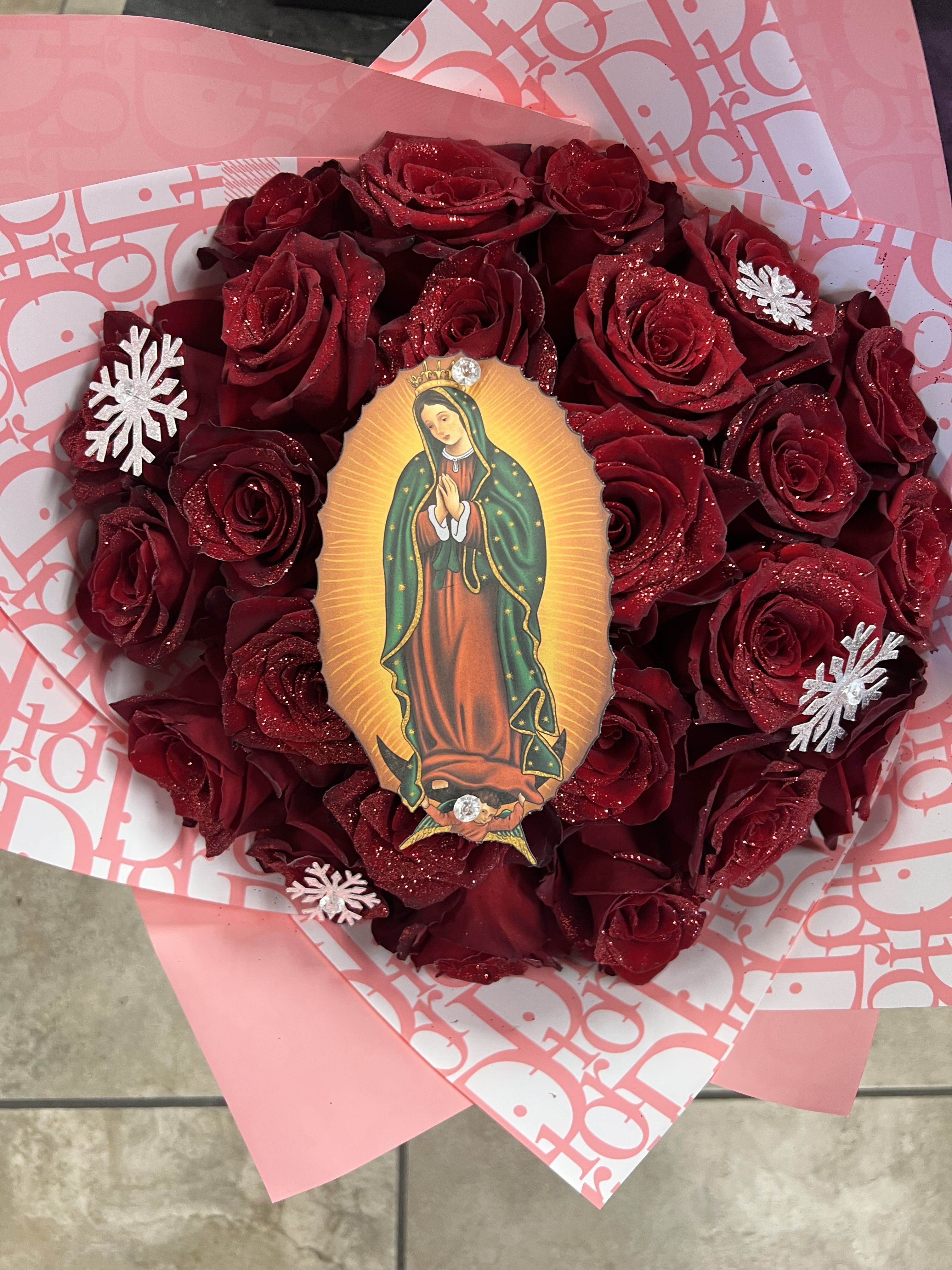 Heart-shaped bouquet of red roses with a religious centerpiece