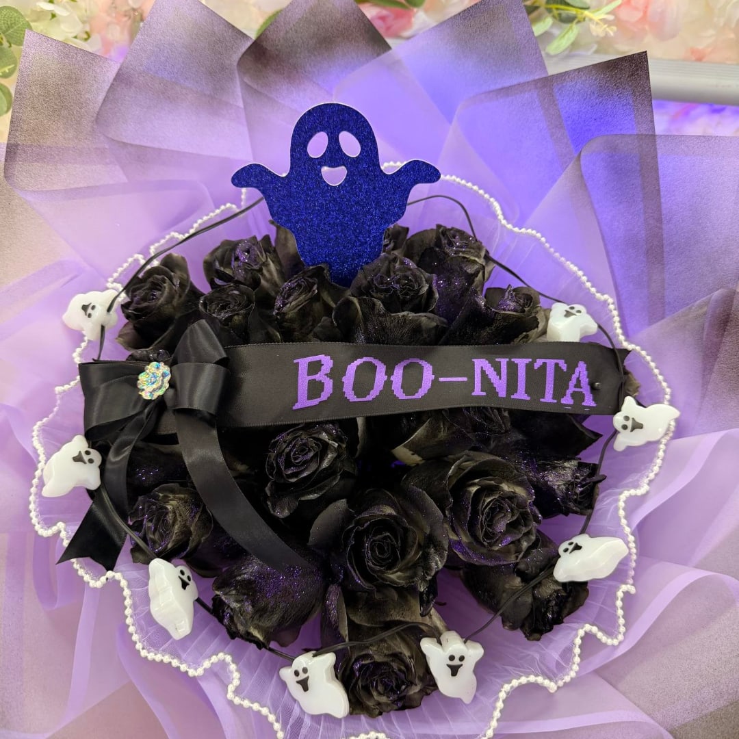 Black roses with a purple ribbon and ghost decorations on lavender wrap