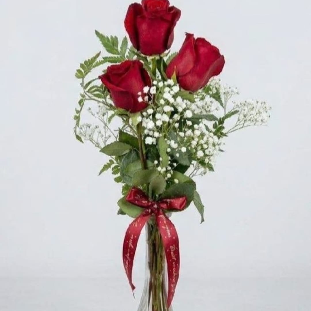 Three red roses with baby's breath and a red ribbon