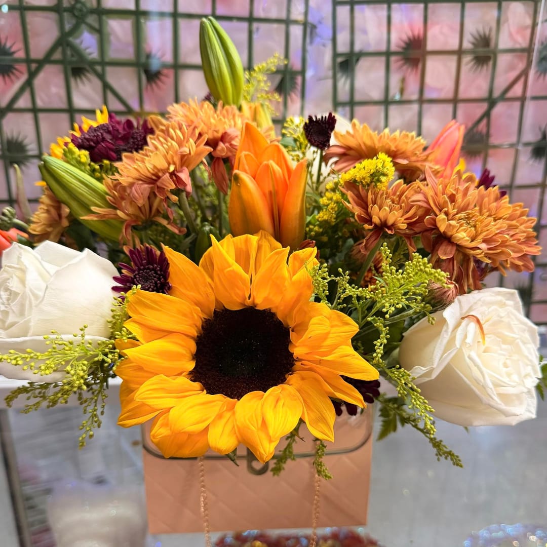 Sunflower and white rose bouquet in a pink gift bag