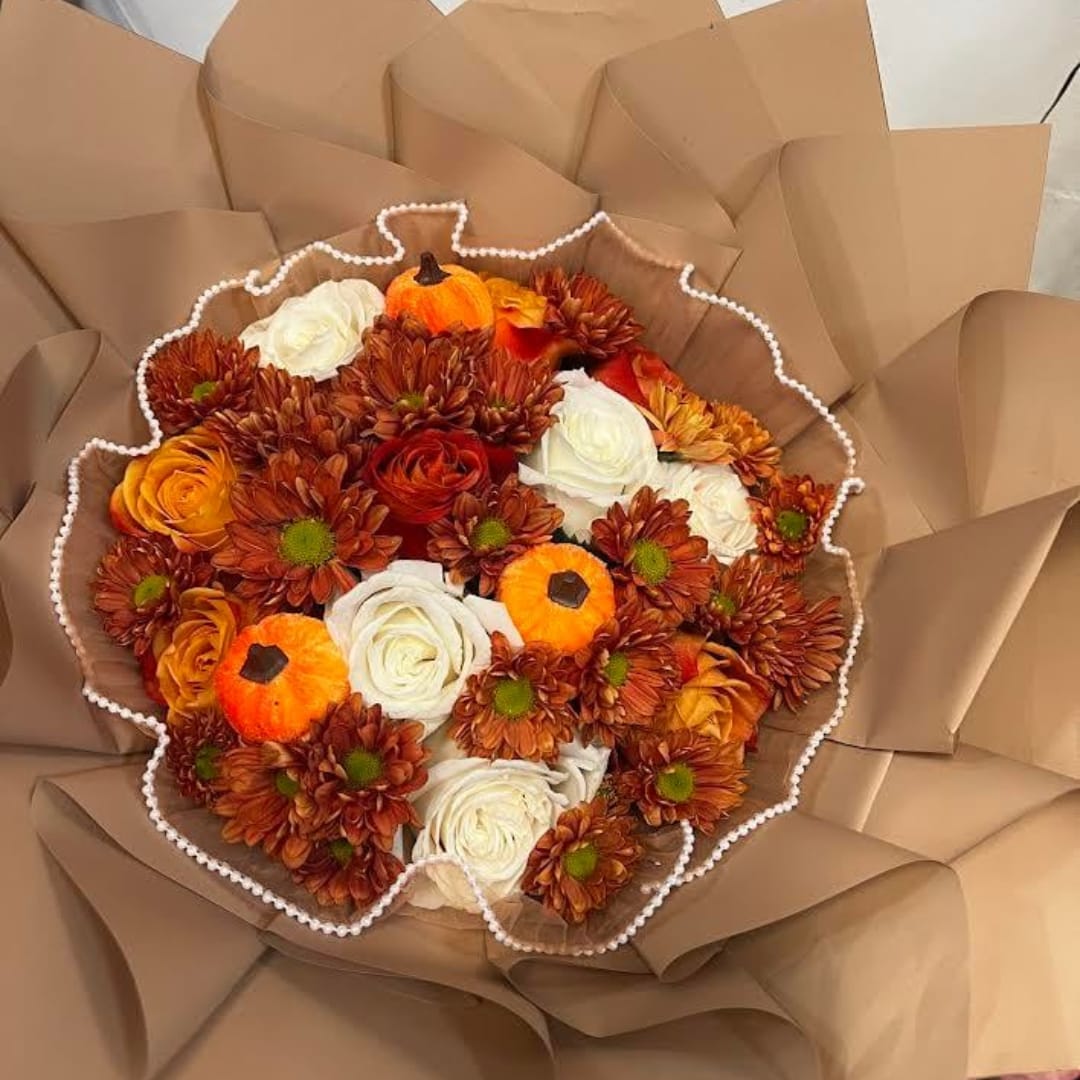 Bouquet of orange and white flowers wrapped in brown paper