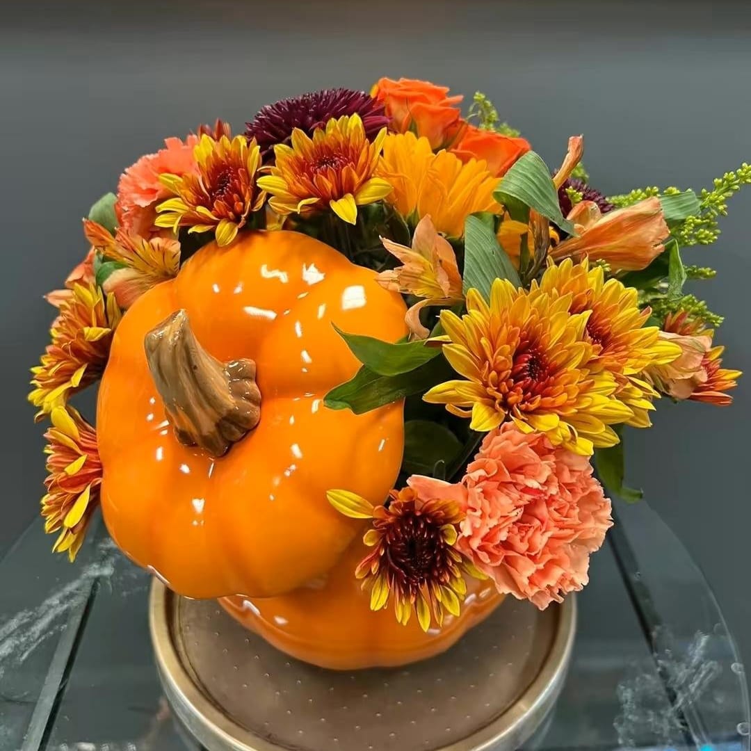 Pumpkin-shaped floral arrangement with orange and yellow blooms