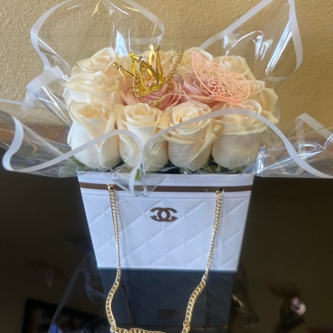 Cream roses in a white gift box with a gold crown topper