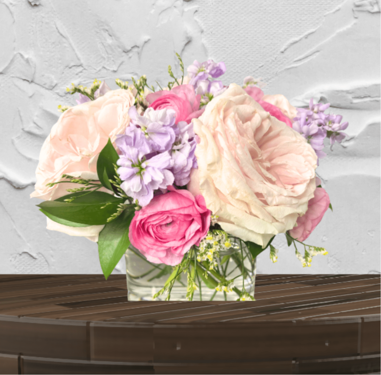 Pink and cream roses arranged in a clear glass vase