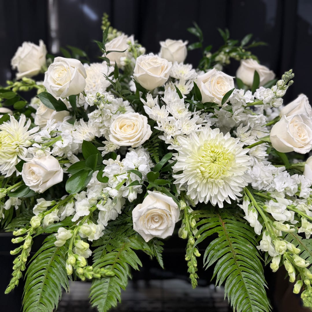 White roses and chrysanthemums arranged with greenery in a low bouquet