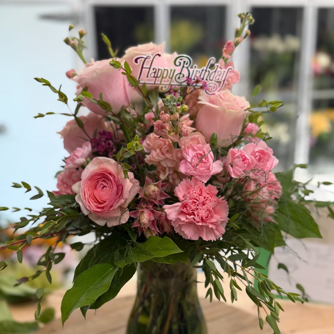 Pink mixed bouquet in a glass vase with a Happy Birthday topper