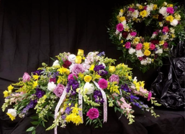 Large mixed floral spray with a matching wreath behind it