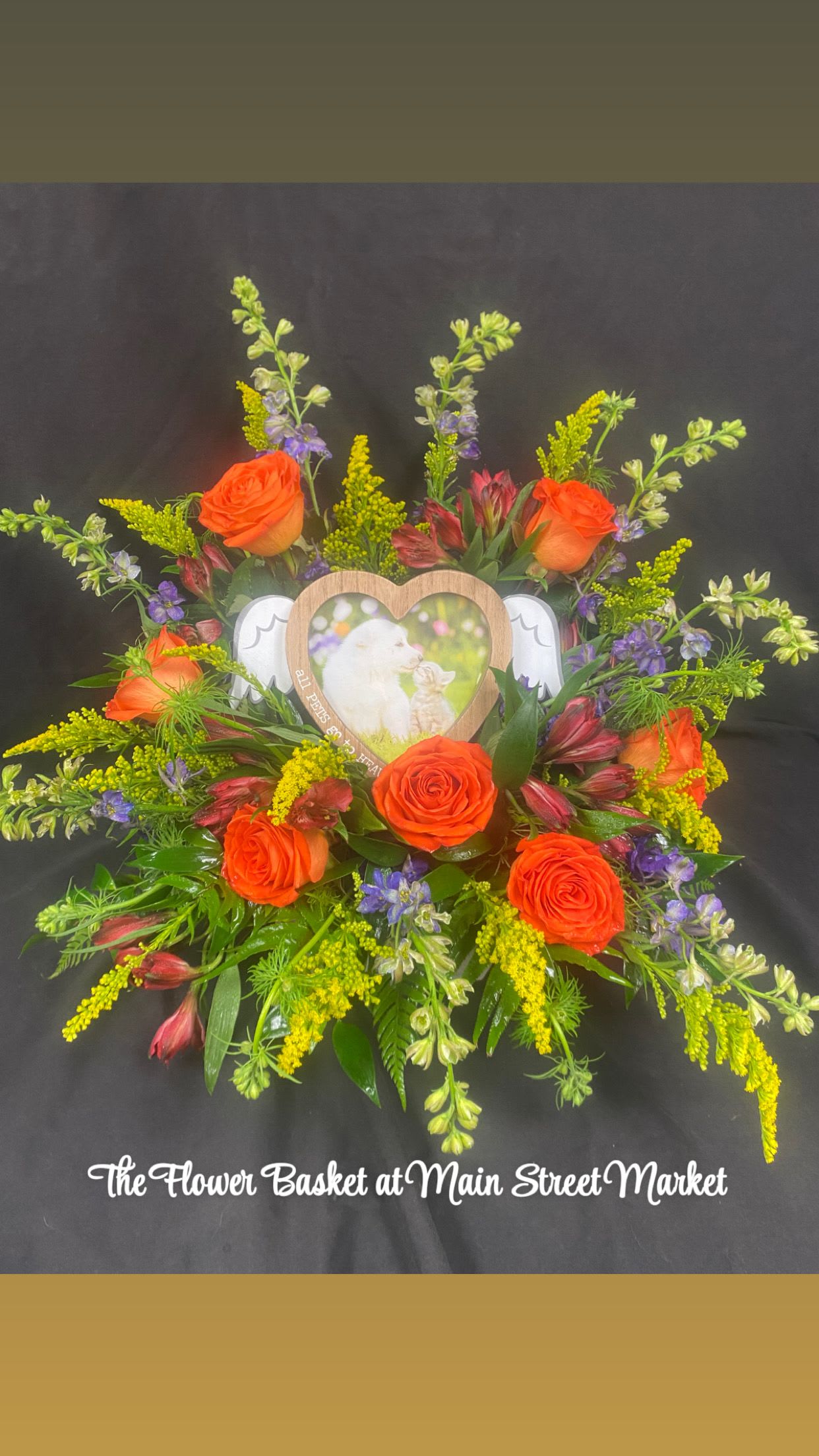 Orange roses arranged around a heart-shaped photo frame