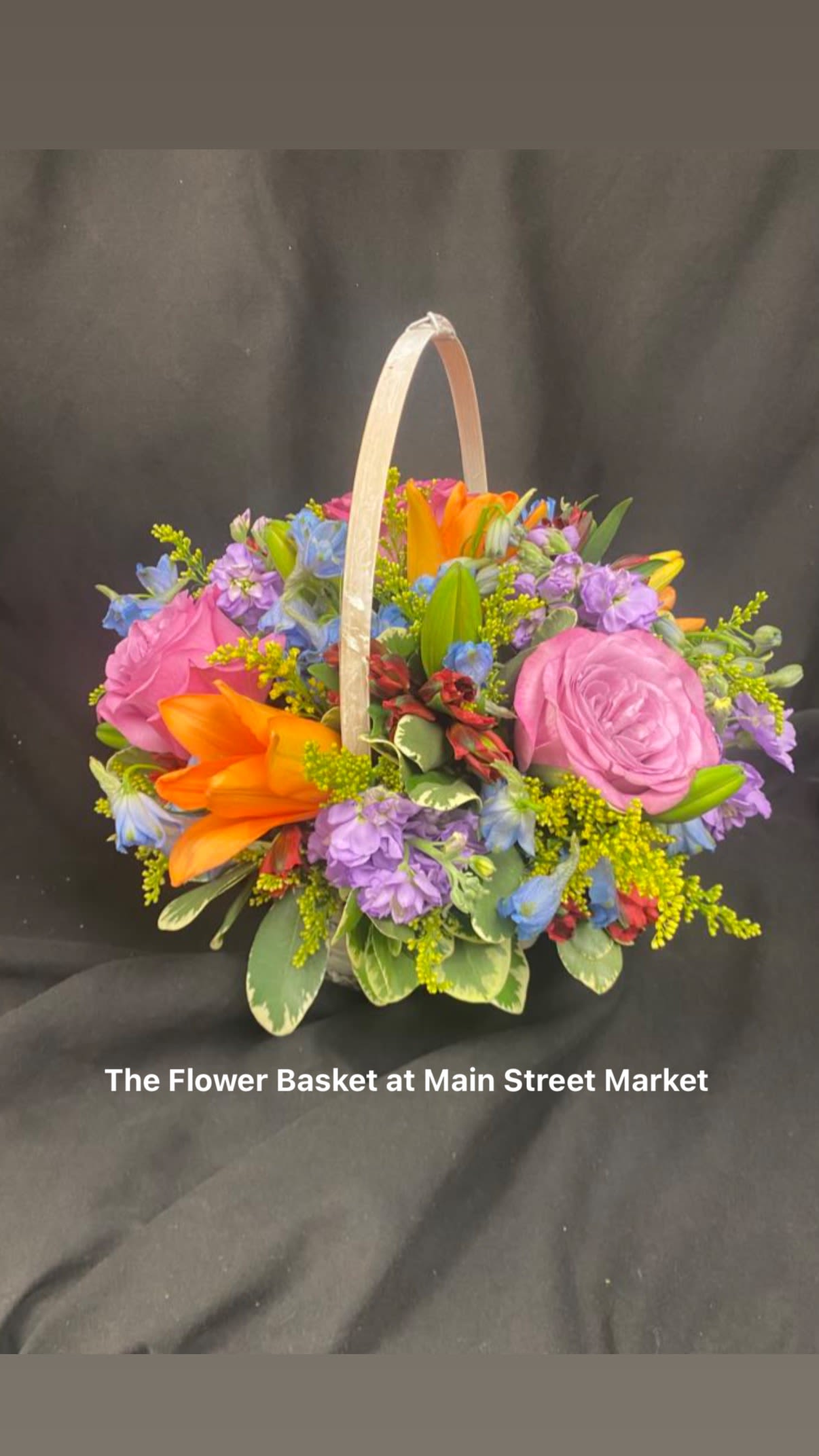 Colorful flower basket with pink roses and orange lilies