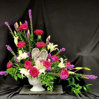 Pink roses and white lilies in a white urn vase
