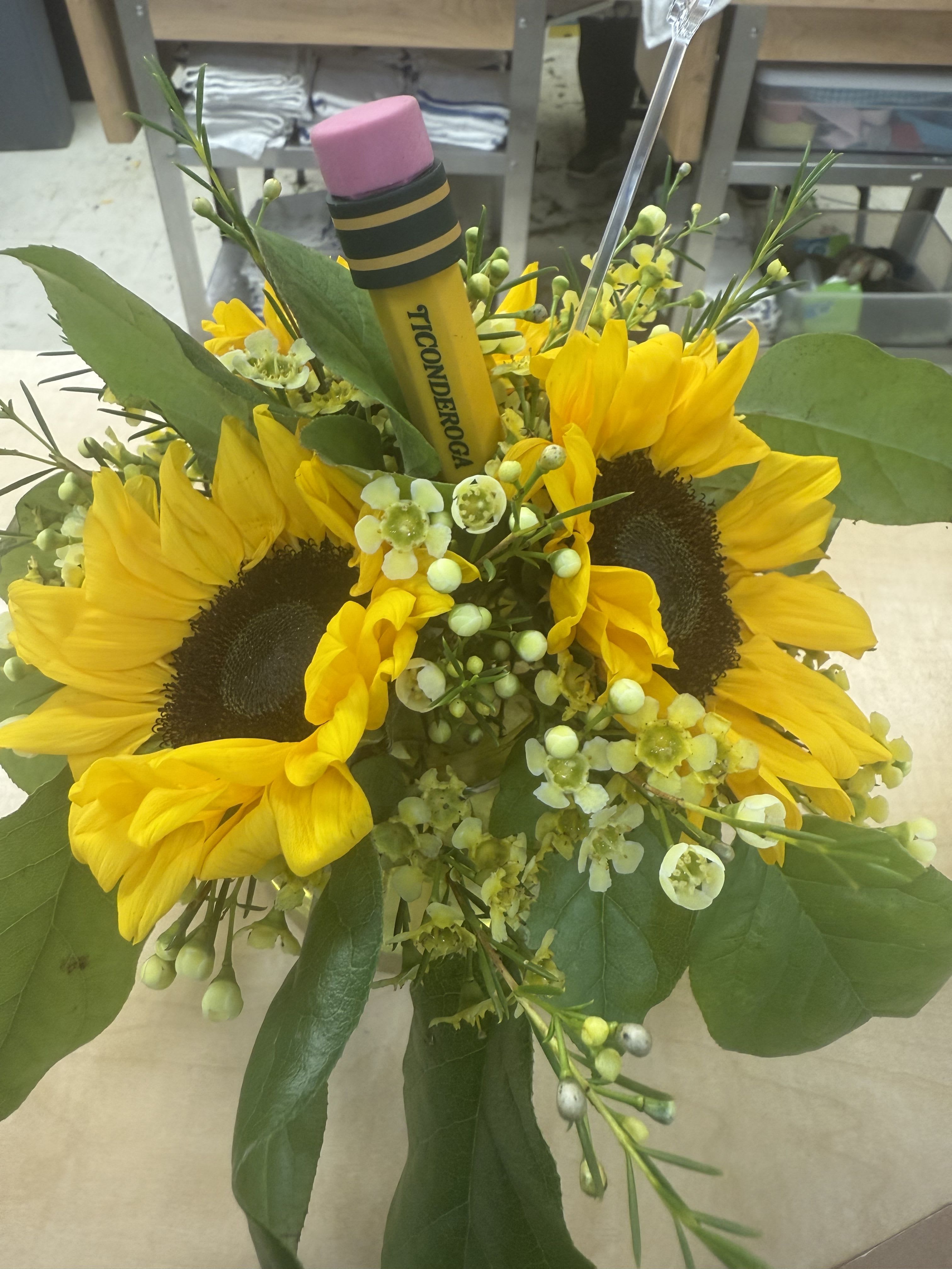 Bouquet of yellow sunflowers with green filler and a pencil topper