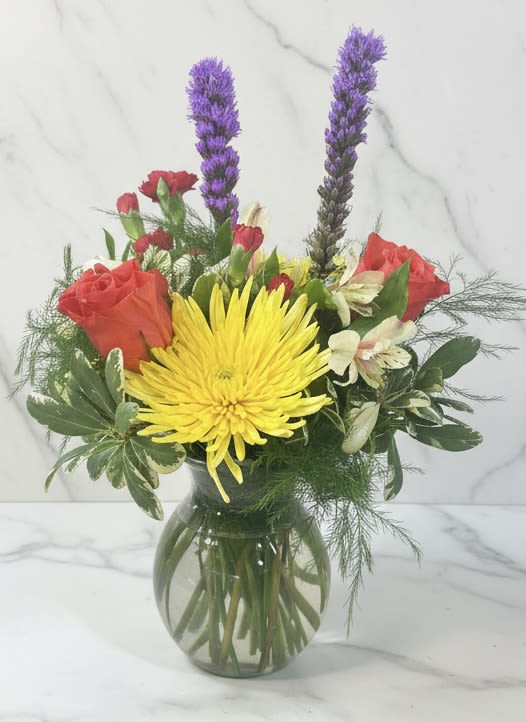 Bouquet of yellow and red flowers in a glass vase