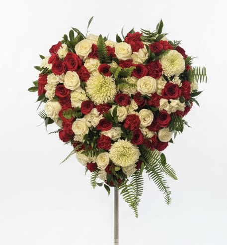 Heart-shaped red and white floral spray on a stand