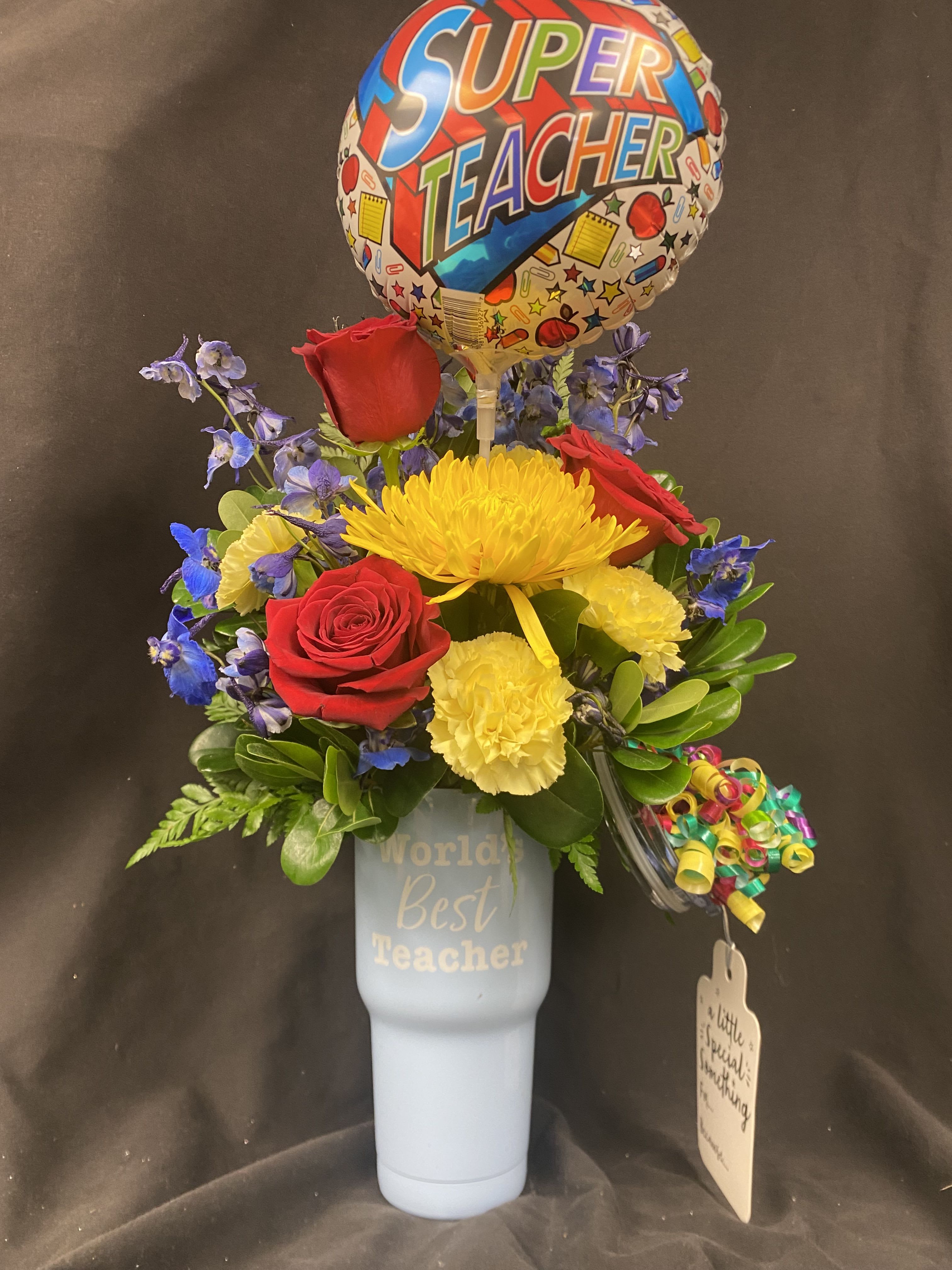 Bouquet of red roses and yellow flowers in a blue tumbler with a teacher balloon