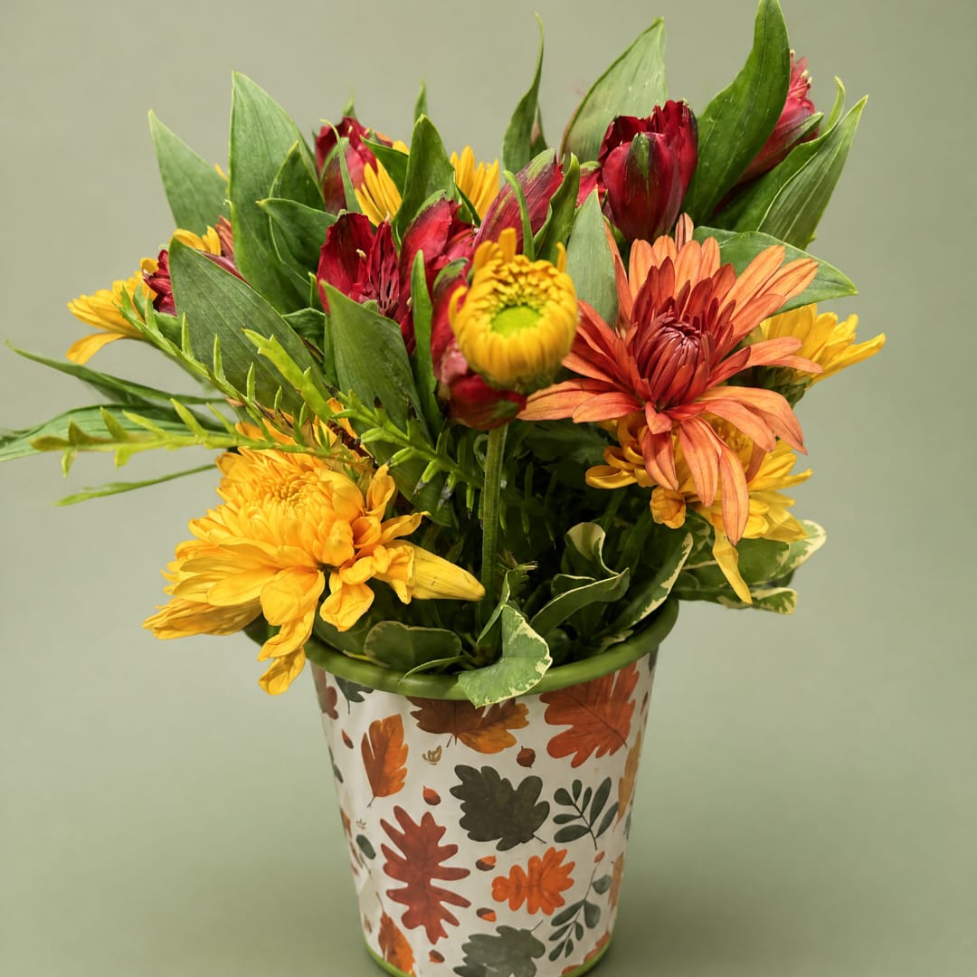 Mixed autumn flowers in a leaf-patterned metal pot