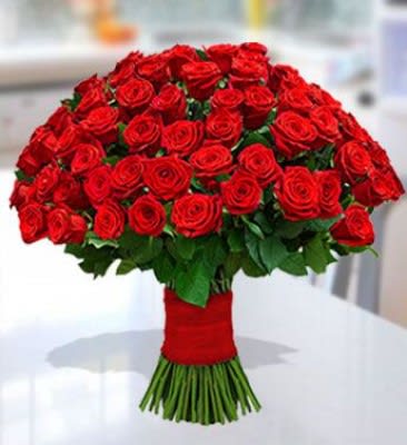 Large bouquet of red roses wrapped at the stems
